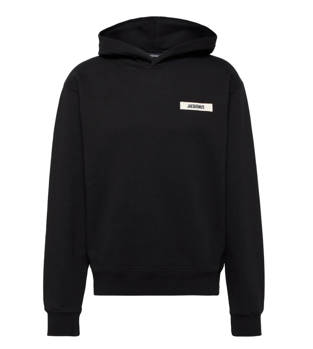 Black hoodie with a small white logo on a light gray background