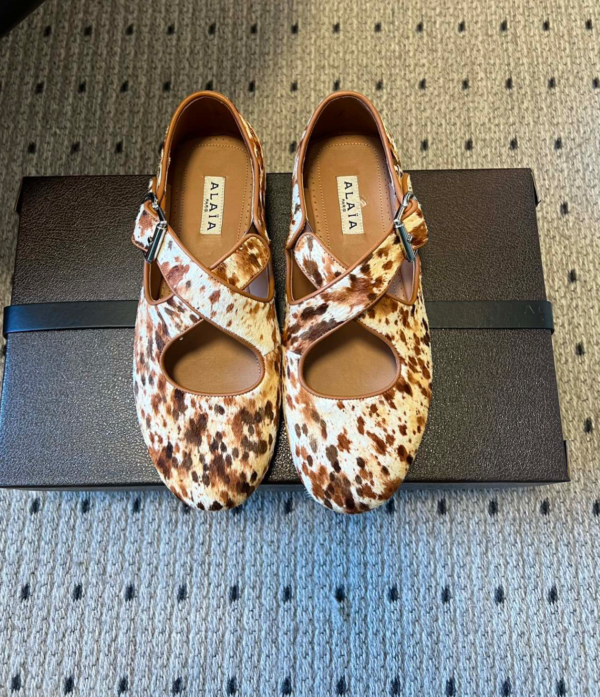 ALAÏA COW PRINT CRISS CROSS BALLET FLATS IN HAIRCALF