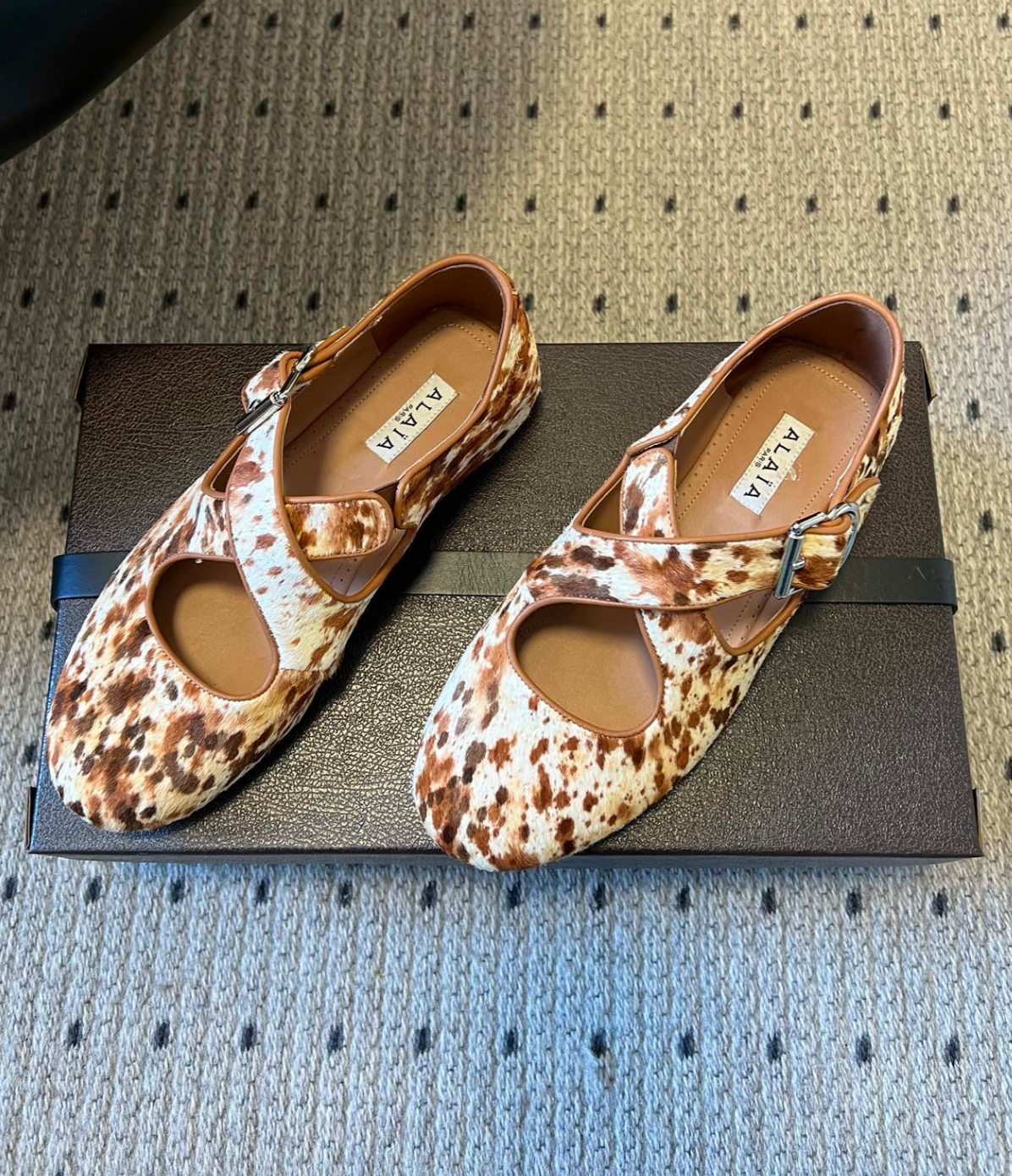 ALAÏA COW PRINT CRISS CROSS BALLET FLATS IN HAIRCALF